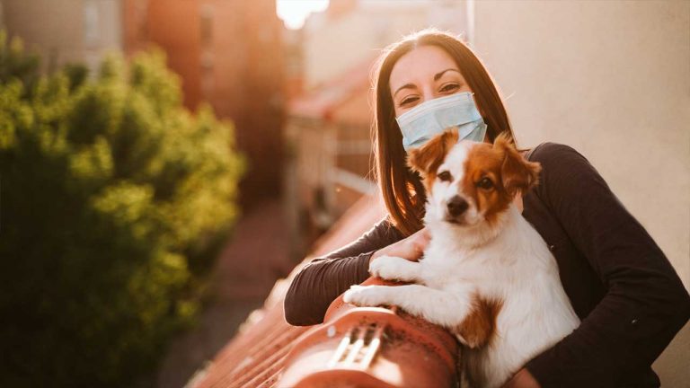 Mulher com mascara e cachorro